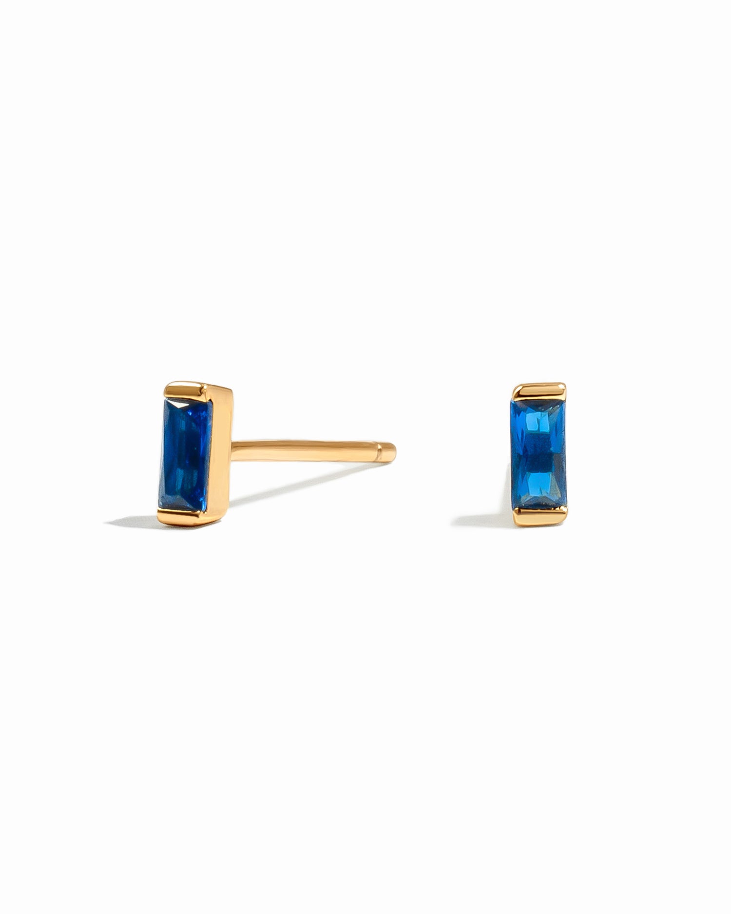closeup image of dainty blue earrings on a white background