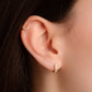 model wearing small hoop earrings featuring a gold huggie hoop dainty earring and a small gold hoop in the cartilage
