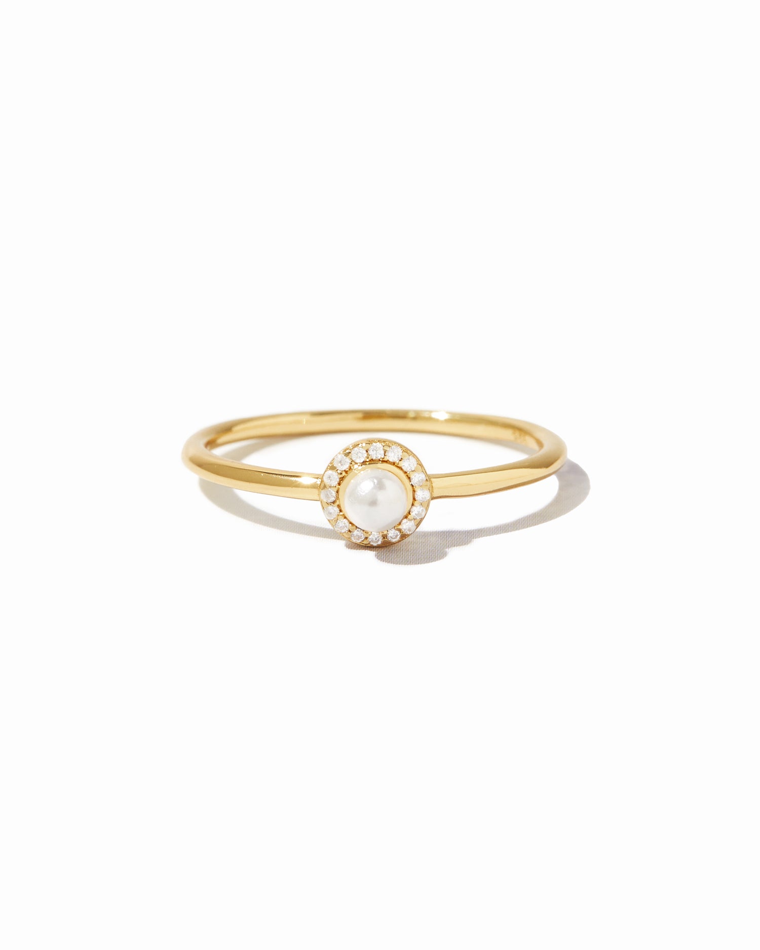 Gold ring with a pearl center on a white background