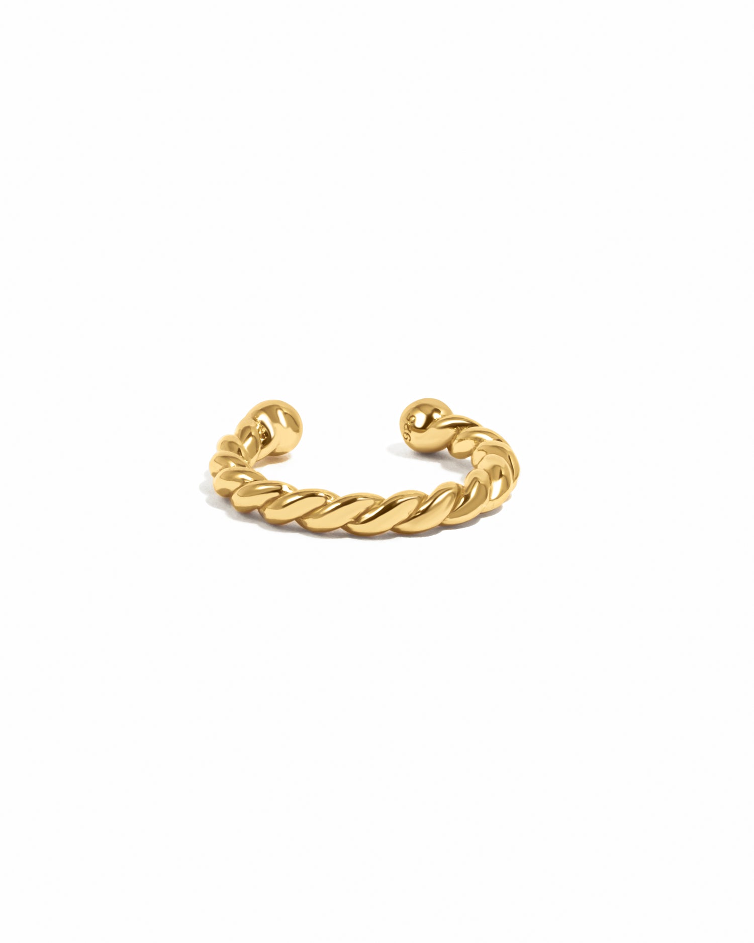 Gold ear cuff on a white background