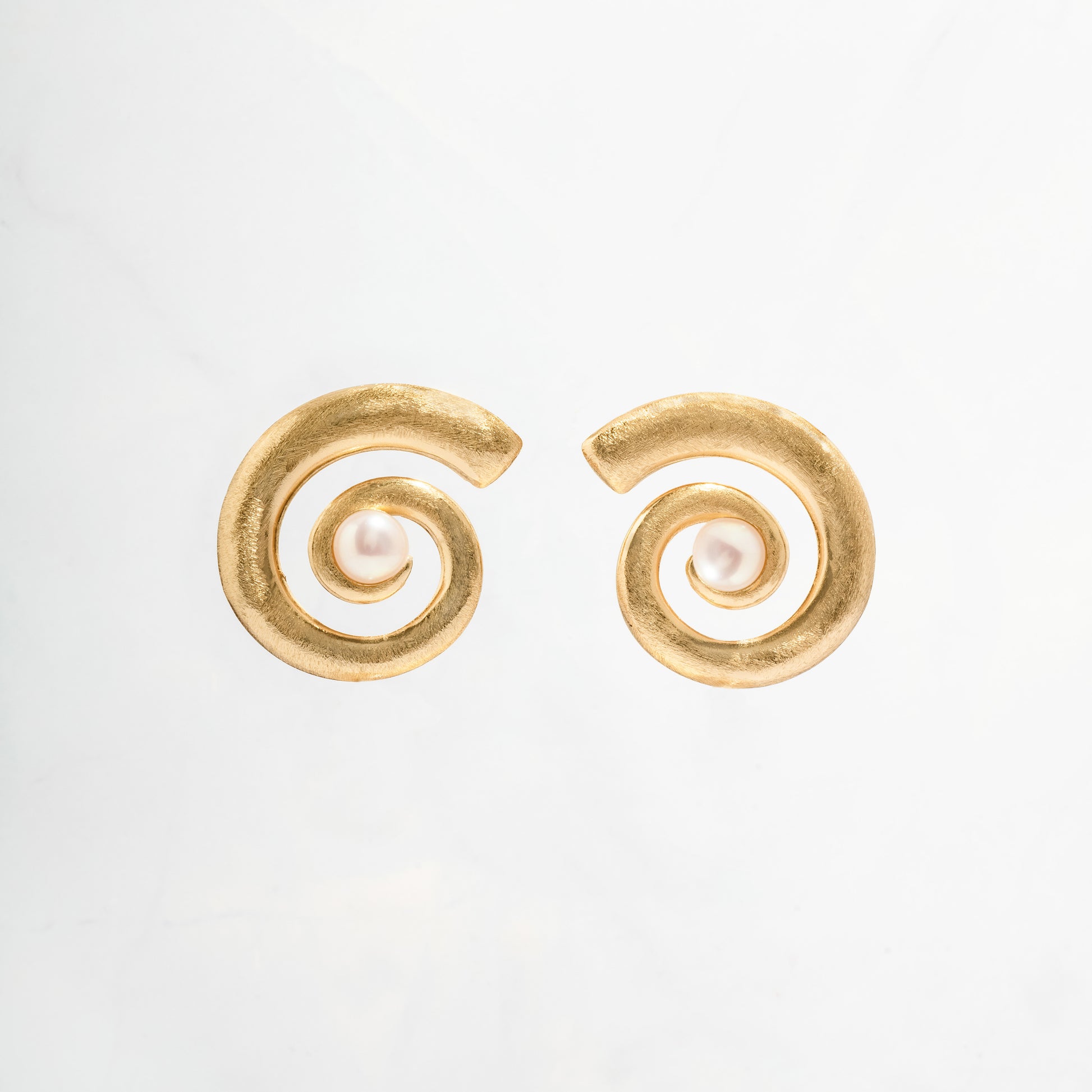 closeup image of gold and pearl earrings