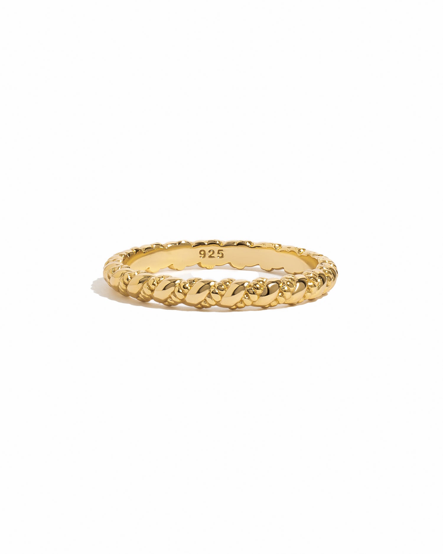Gold ring with intricate spiral design on a white background