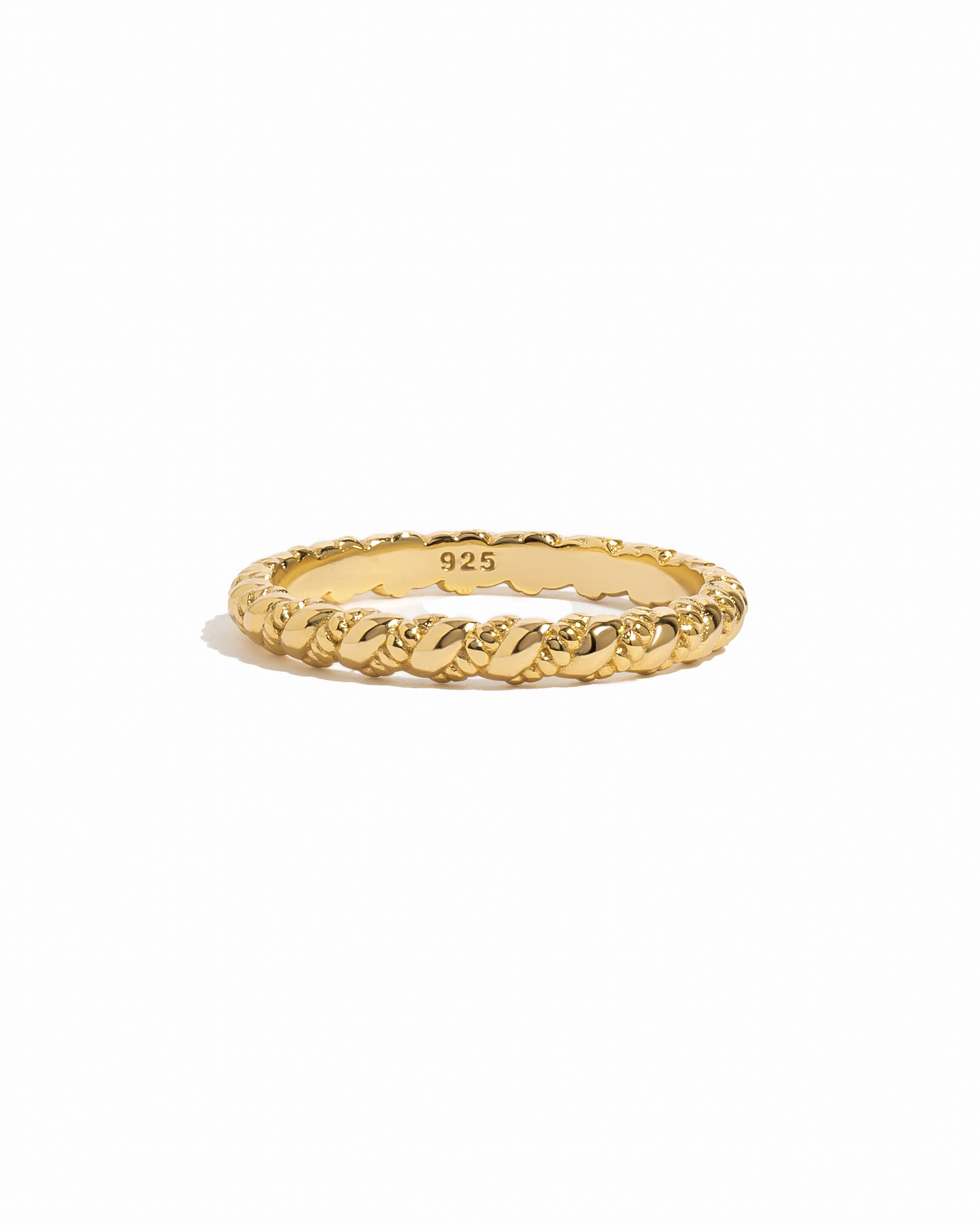 Gold ring with intricate spiral design on a white background