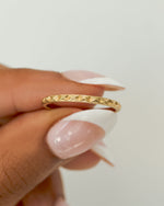 Gold vintage ring for women being held by a hand with a white background