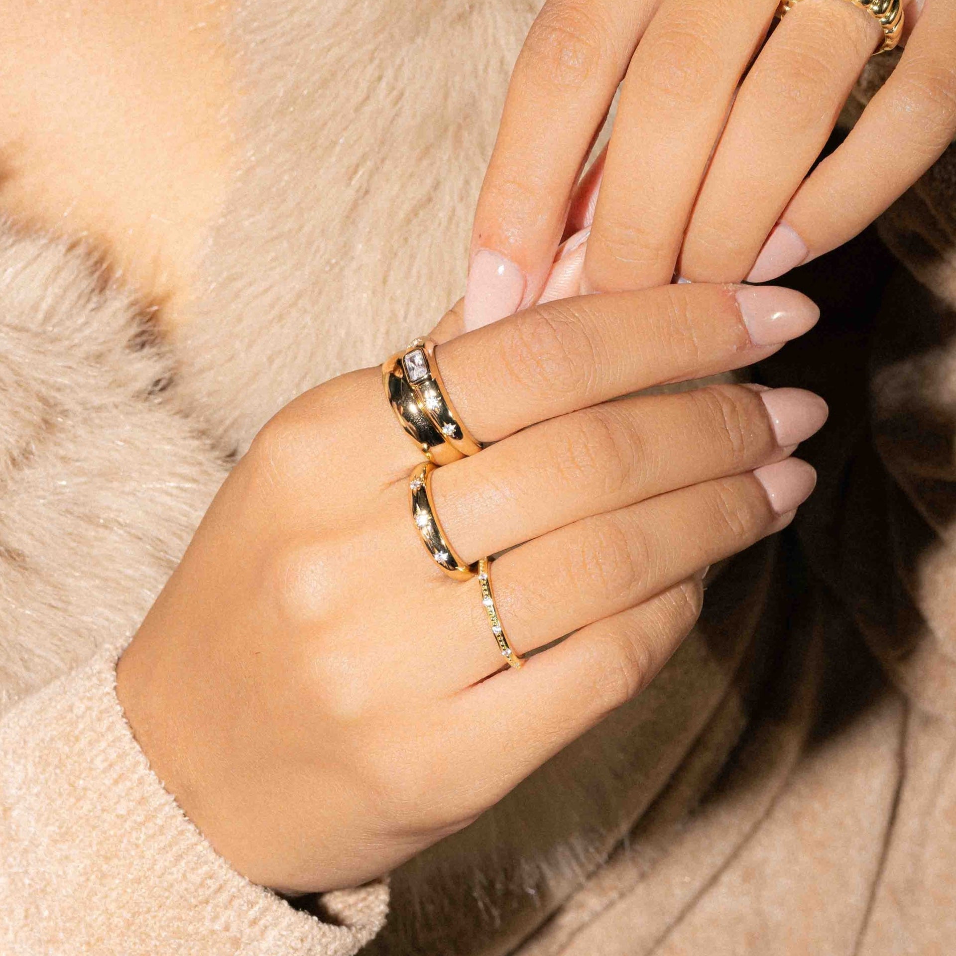 model wearing gold stacking band featuring thin starburst ring