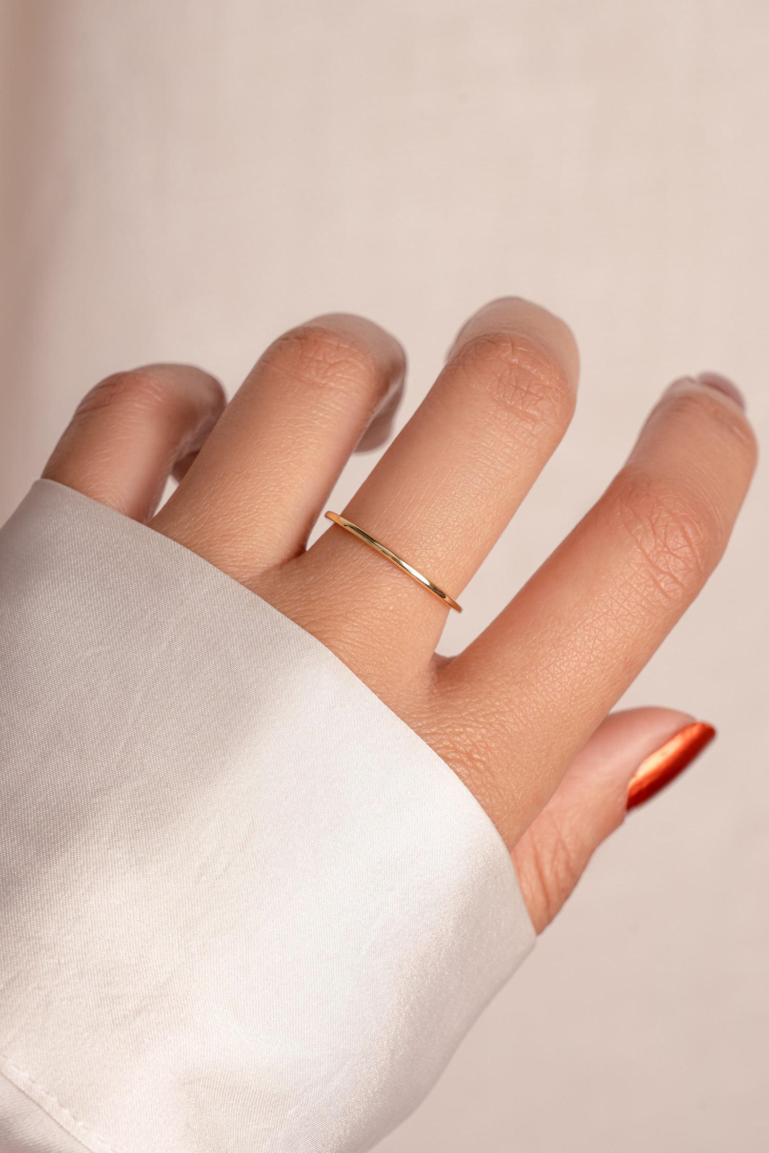 Delicate thin gold ring on model.