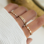 Model wearing minimalist gold stacking rings with dainty diamond rings