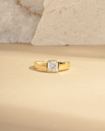closeup image of gold dome ring on a beige background