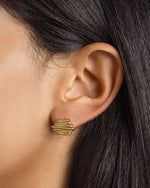 Gold dainty stud earrings on model