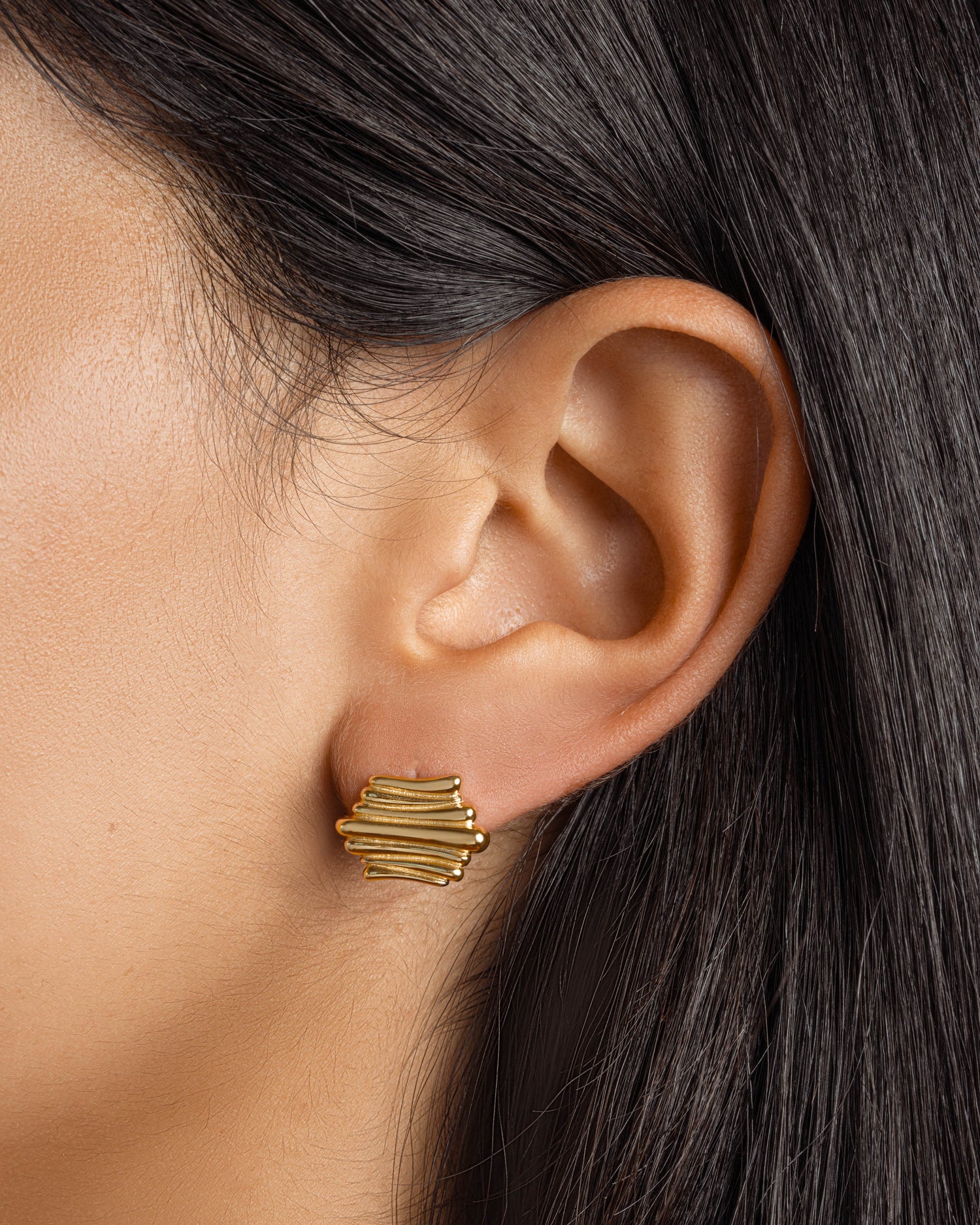 Gold dainty stud earrings on model