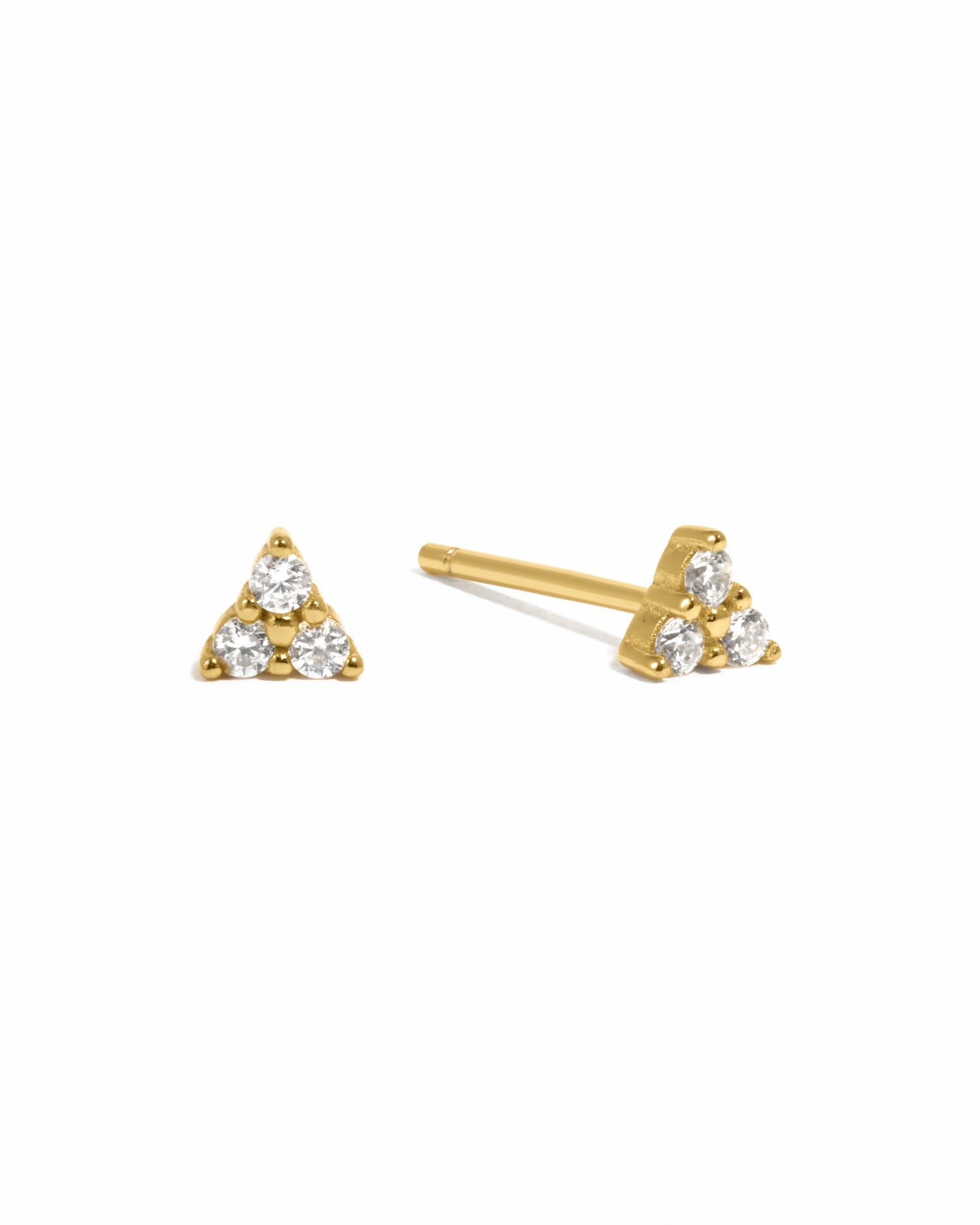 Gold triangle-shaped earrings with three white cz gemstones on a white background