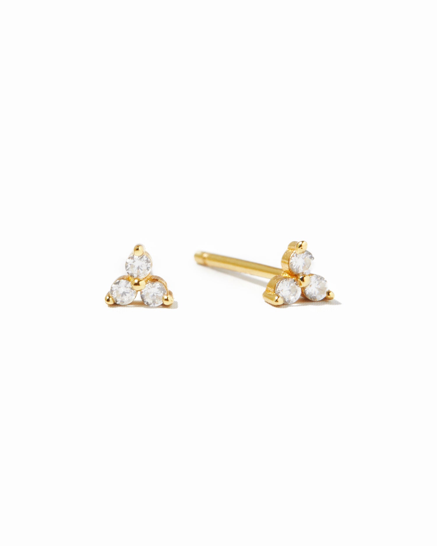 Gold triangle-shaped earrings with three white cz gemstones on a white background
