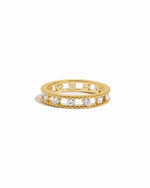 Gold ring with embedded cubic zirconia diamonds around a gold eternity band on a white background