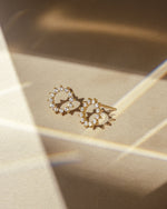 Pair of diamond stud earrings on a gold surface