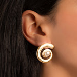 model wearing pearl earrings featuring a swirl earring design
