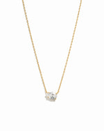 Gold necklace with a small diamond pendant on a white background