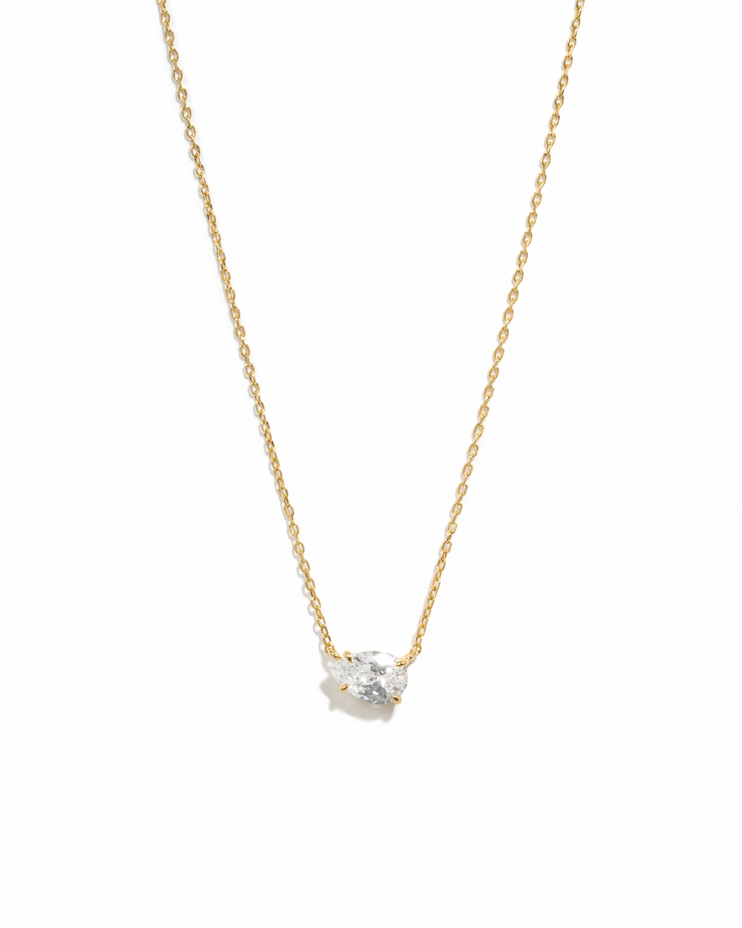 Gold necklace with a small diamond pendant on a white background