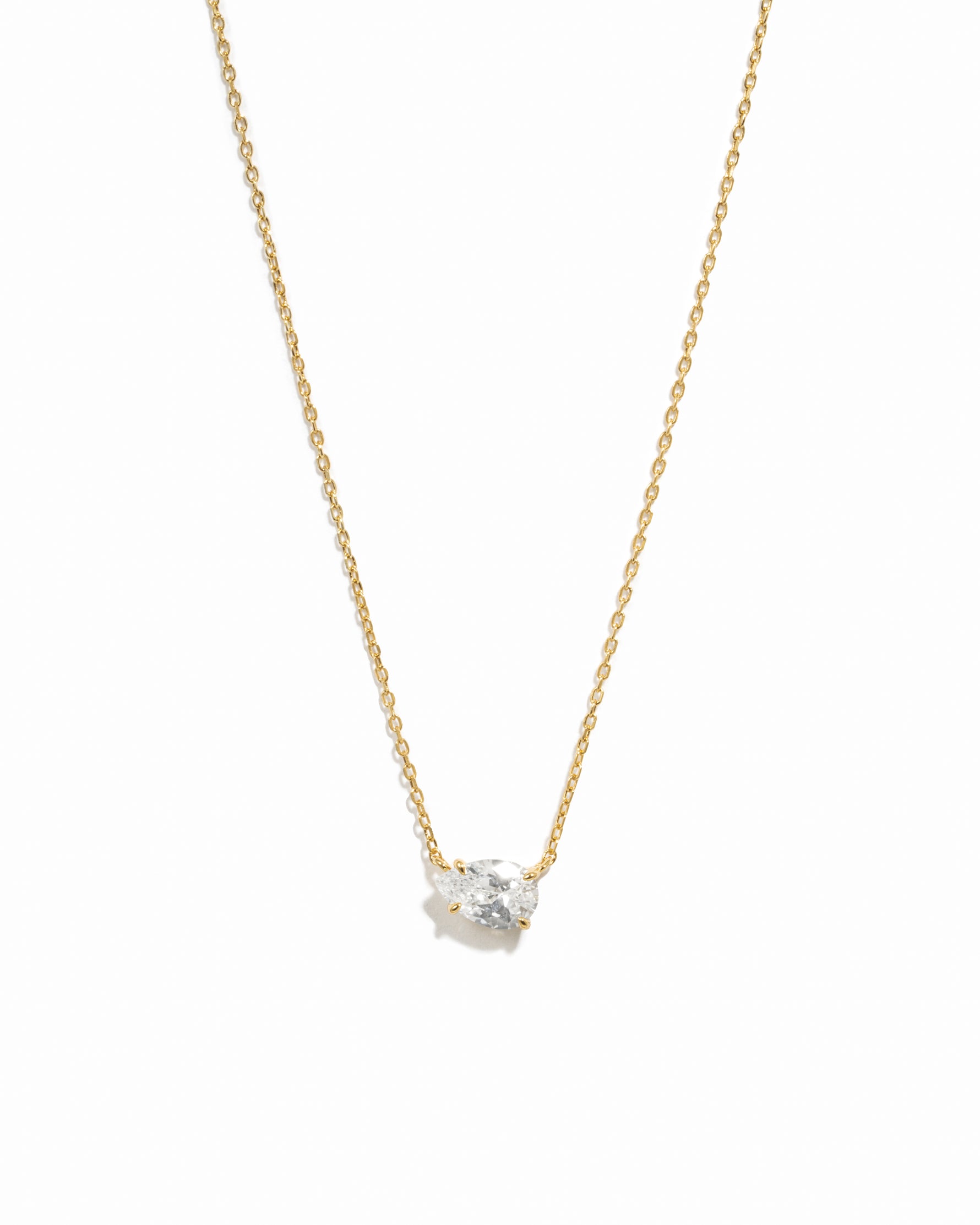 Gold necklace with a small diamond pendant on a white background
