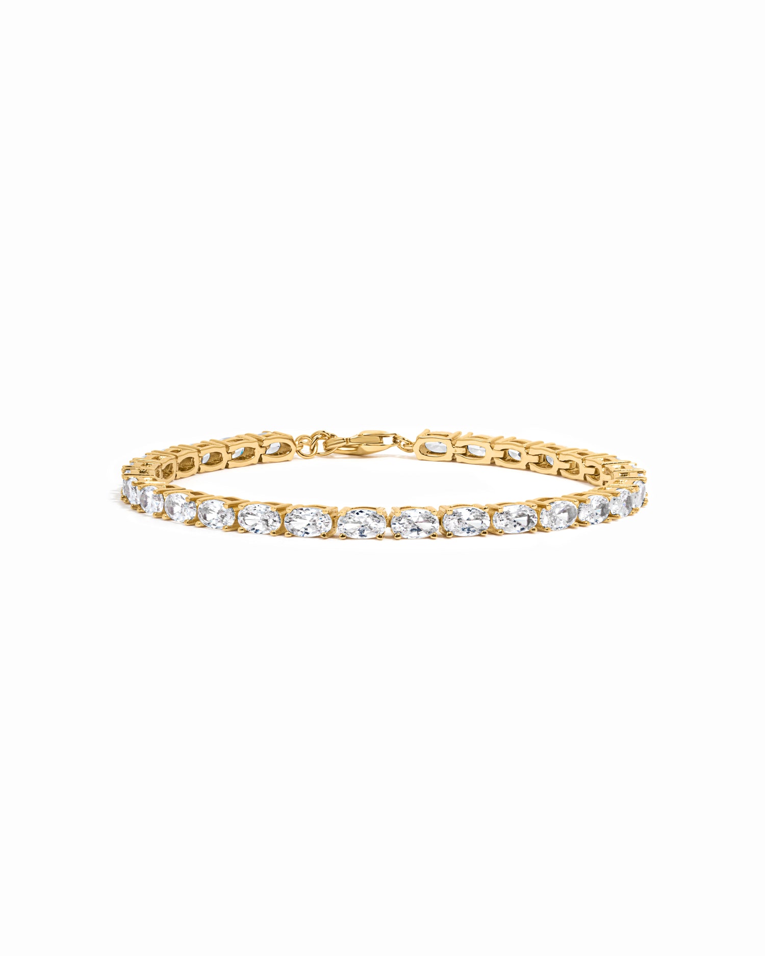 Gold tennis bracelet with oval diamond cubic zirconia stones on a white background