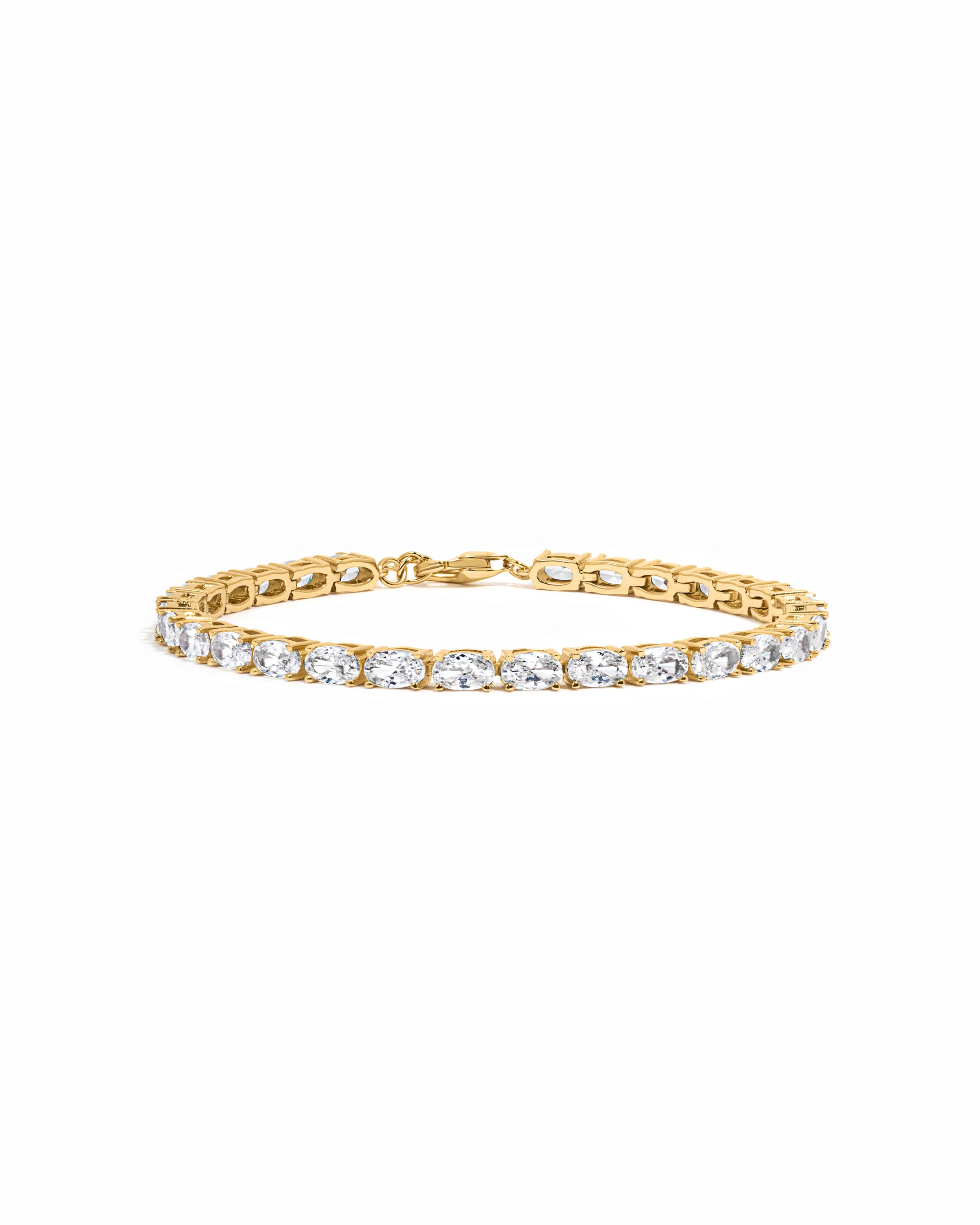 Gold tennis bracelet with oval diamond cubic zirconia stones on a white background