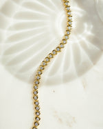 closeup image of heart shaped tennis bracelet in gold