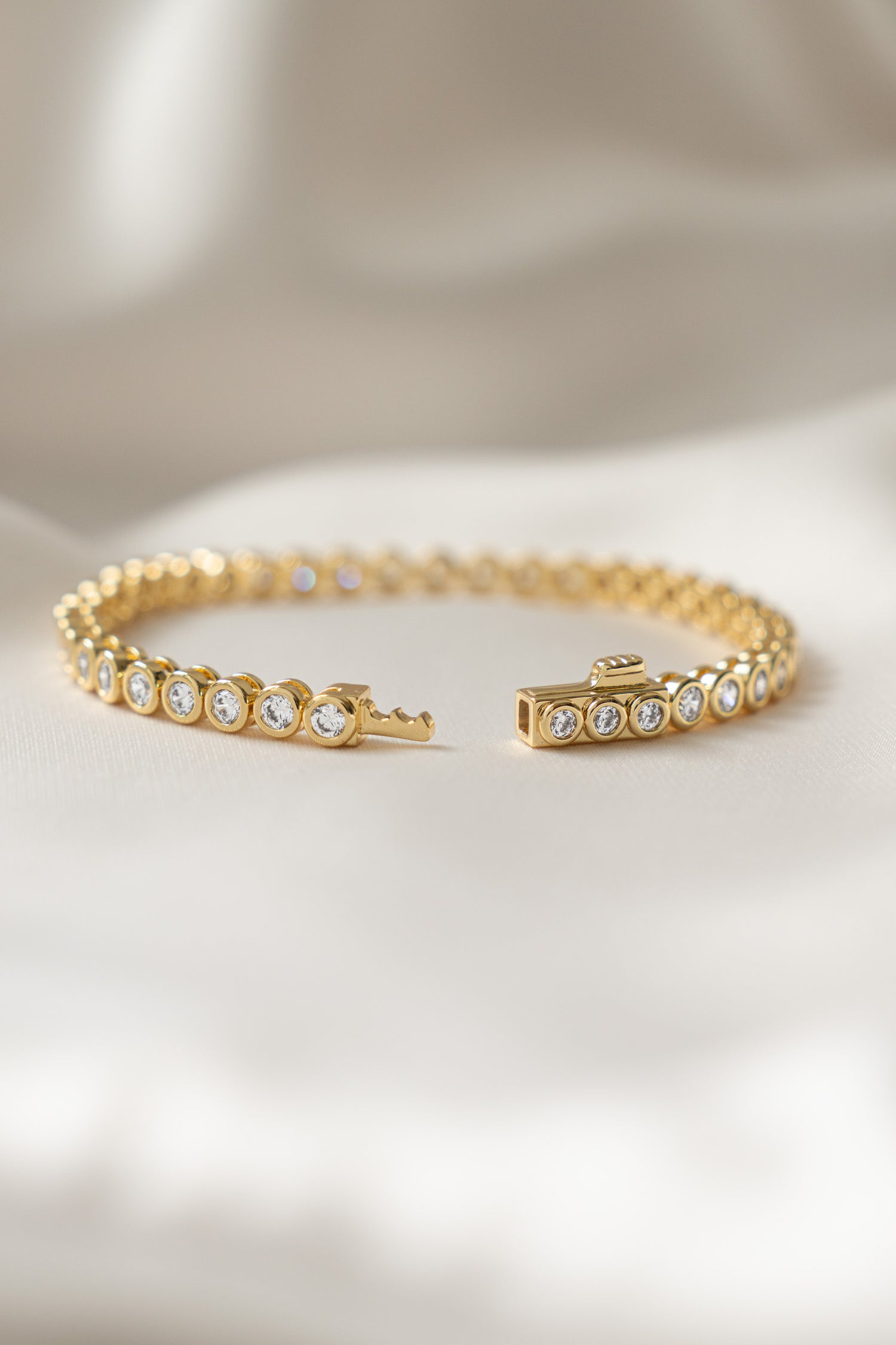 round bezel gold tennis bracelet