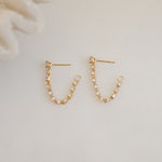 close up of gold chain stud earrings with tennis link design, perfect for a layered jewelry look.