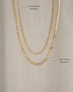 closeup image two bezel set gold tennis necklaces, one in 2.5mm and one in 3mm