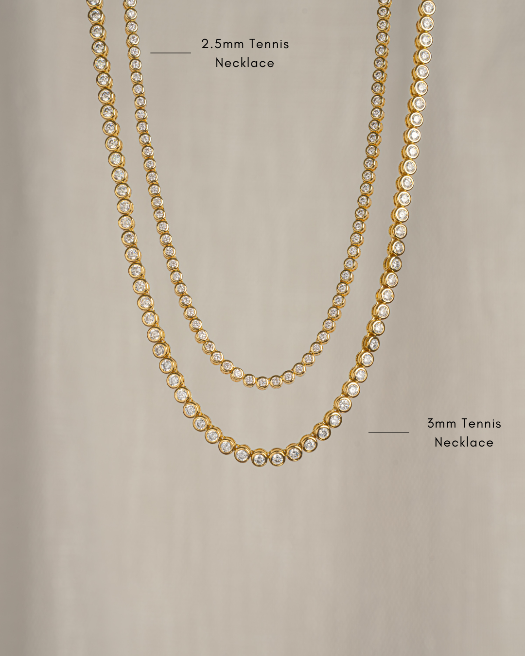 closeup image two bezel set gold tennis necklaces, one in 2.5mm and one in 3mm