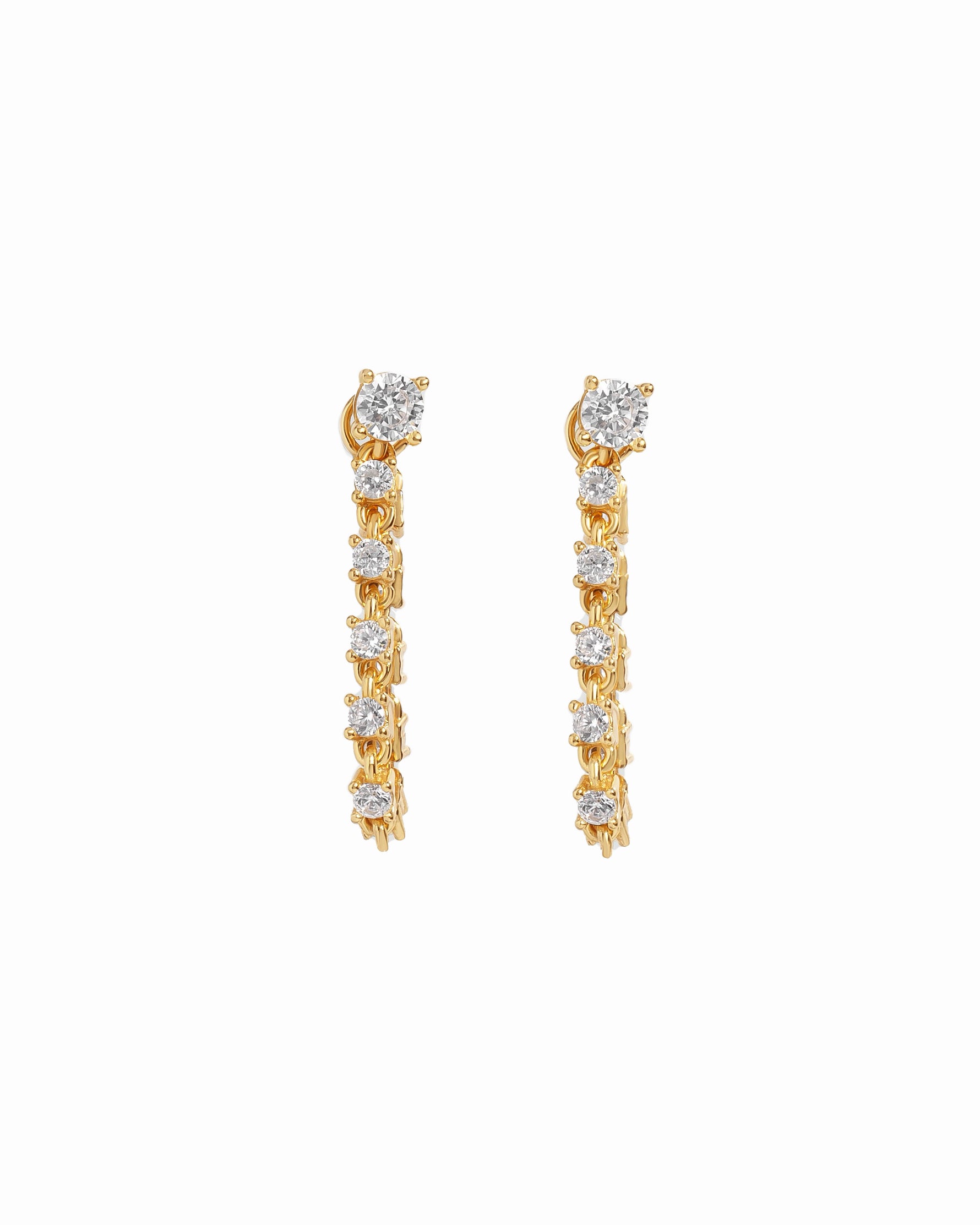 Gold tennis stud earrings with diamond-like stones on a white background