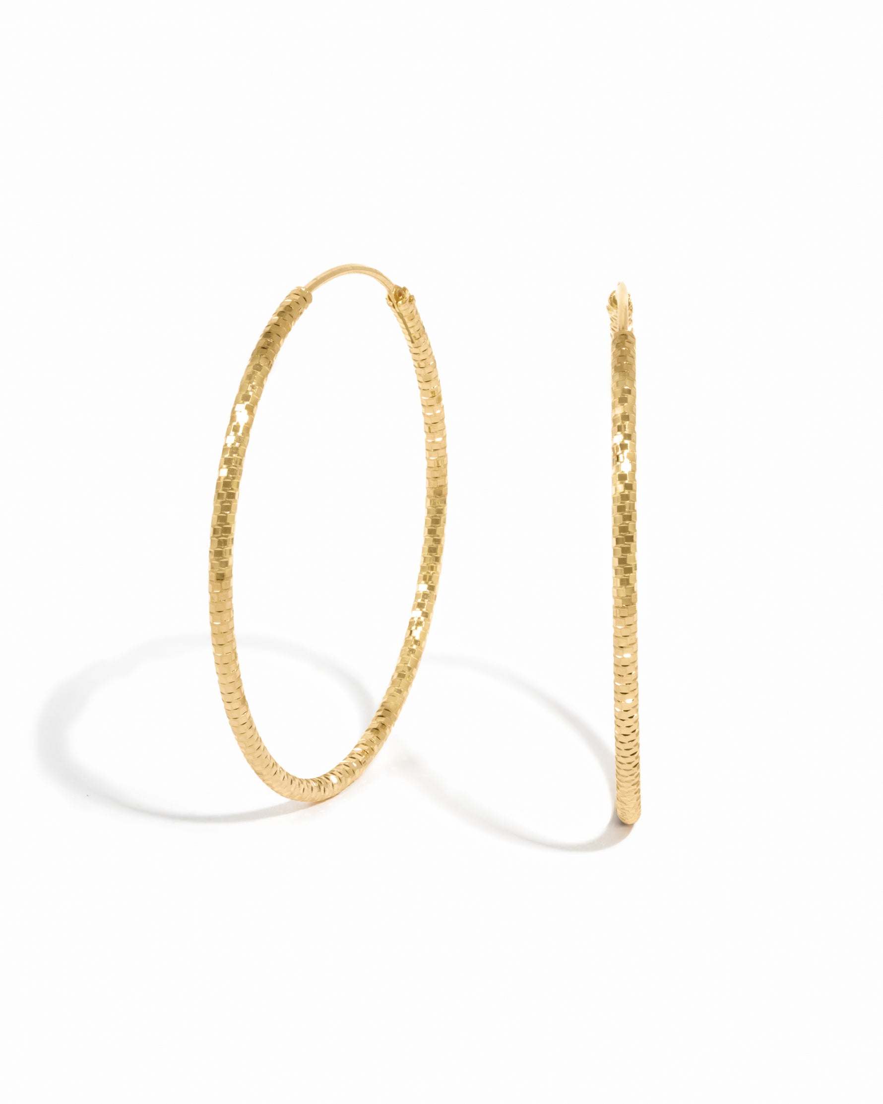 Gold lightweight earrings featuring a diamond hoop earring design on a white background