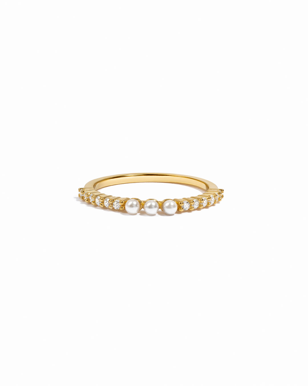 Gold ring with three dainty pearls and diamond accents on a white background