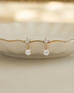 Gold diamond earrings hanging on decorative plate