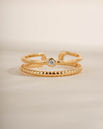 Gold foot jewelry featuring a gold adjustable toe ring with a neutral background