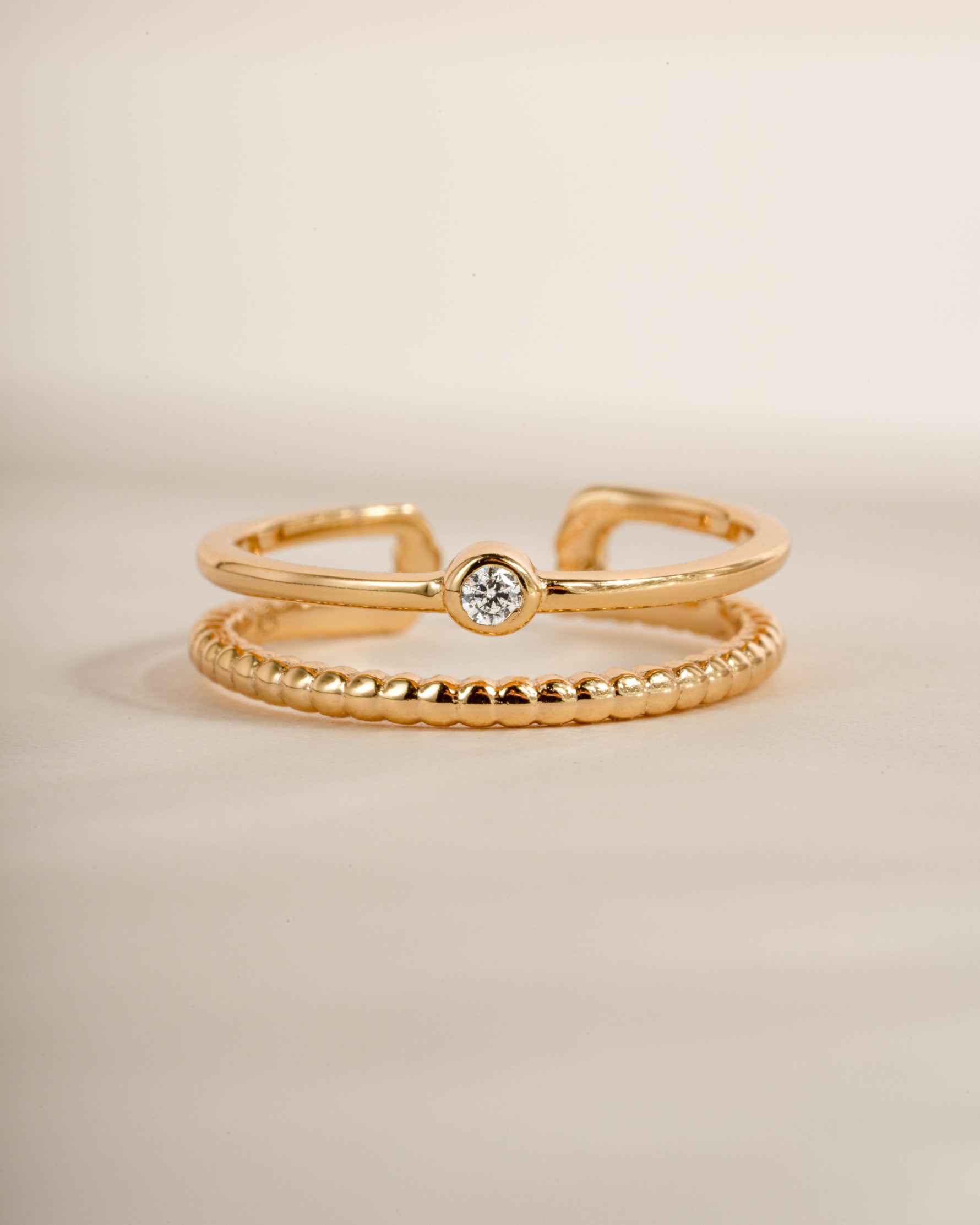 Gold foot jewelry featuring a gold adjustable toe ring with a neutral background