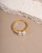 Gold minimalist promise ring on biege surface