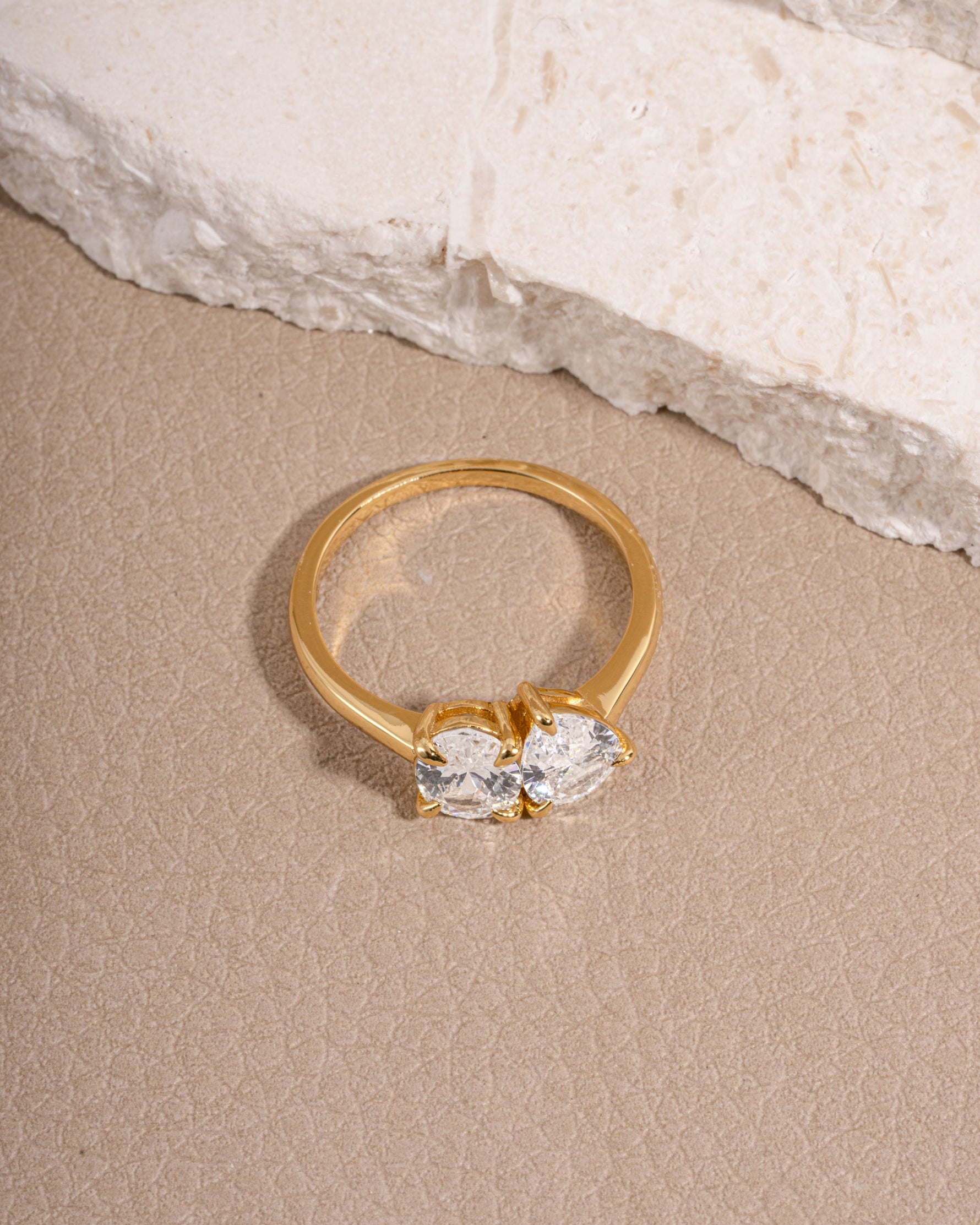 Gold minimalist promise ring on biege surface