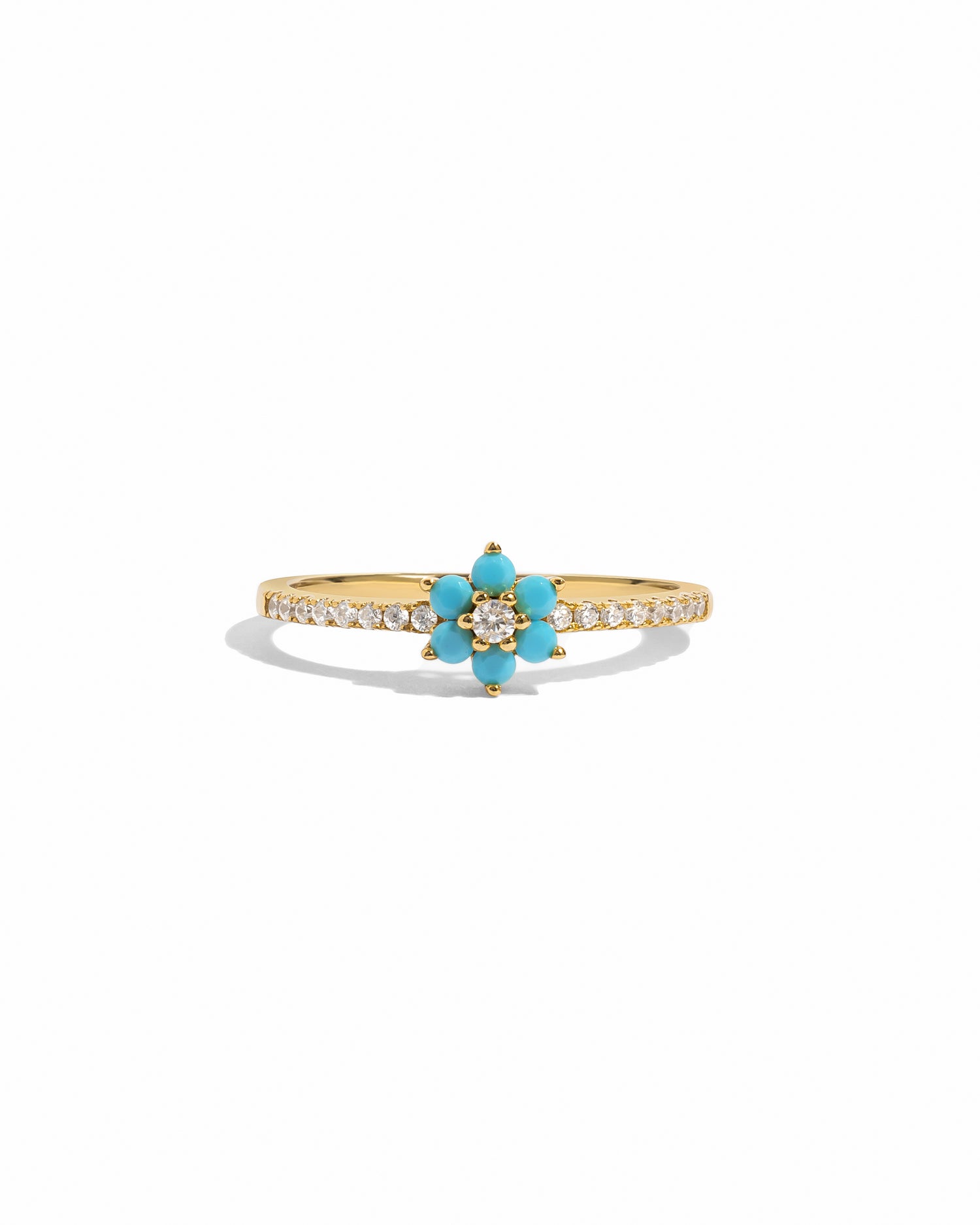 Gold ring with turquoise flower and white cz stones on a white background