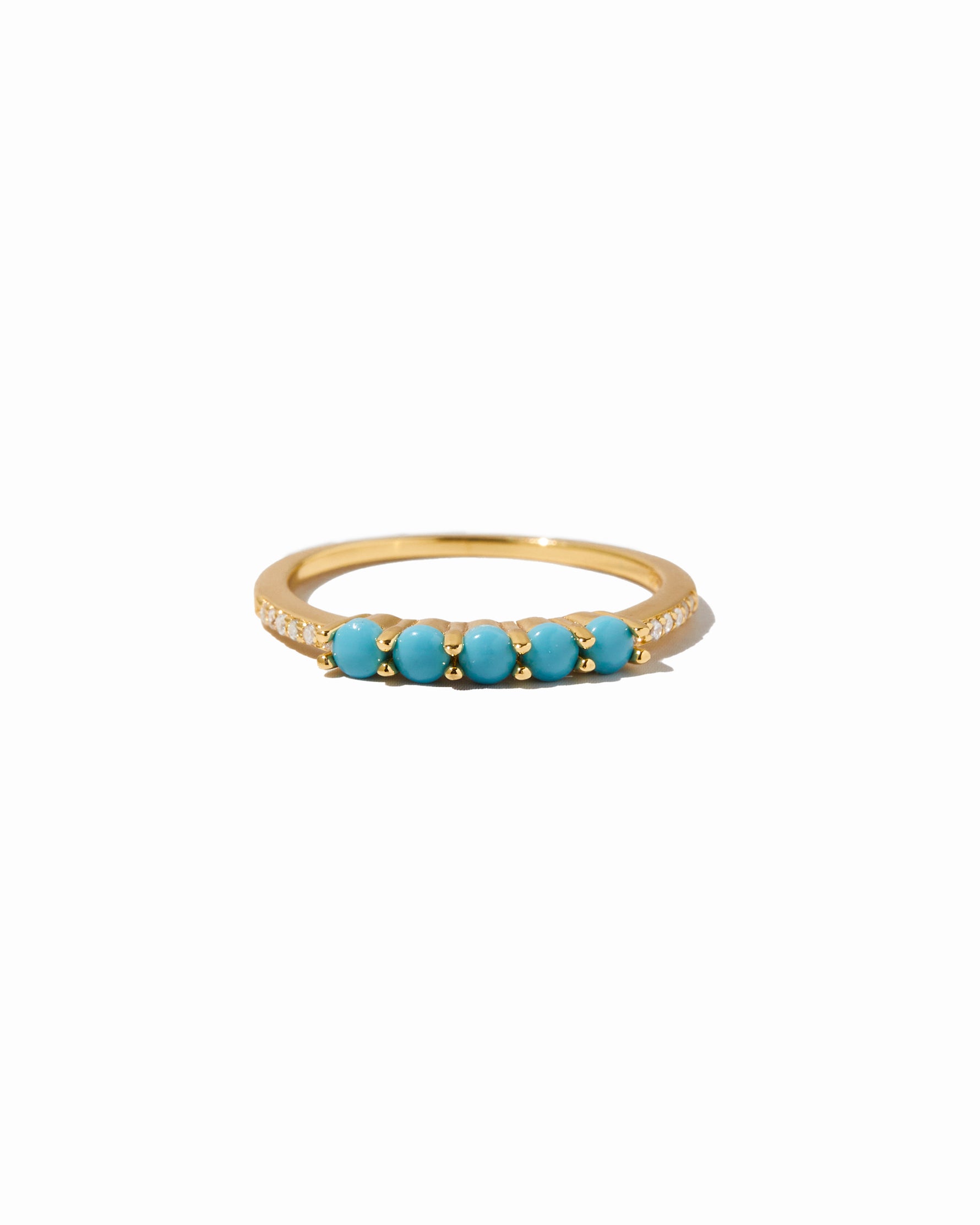 Gold ring with turquoise stones on a white background