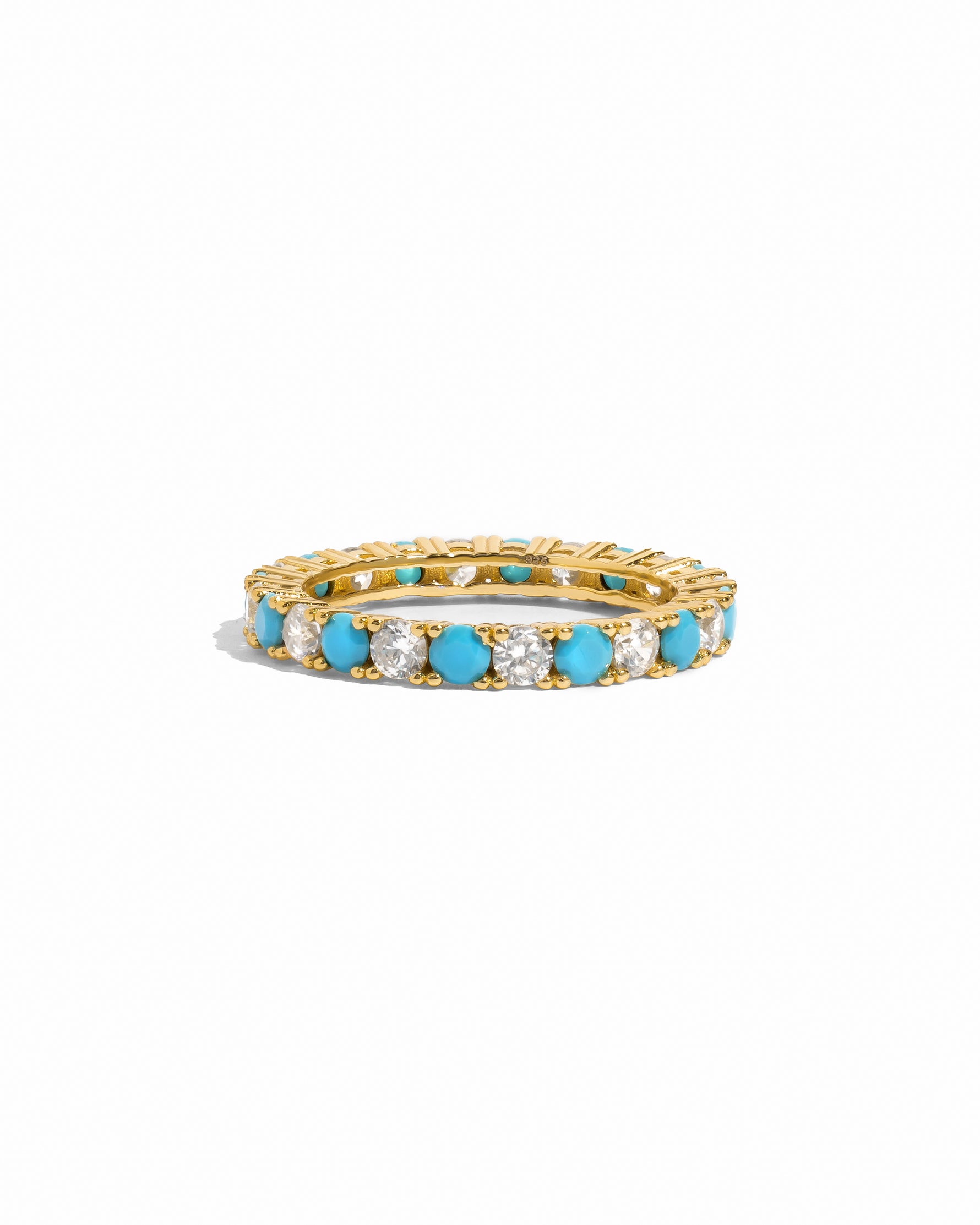 Gold eternity ring with turquoise and white cz gemstones on a white background