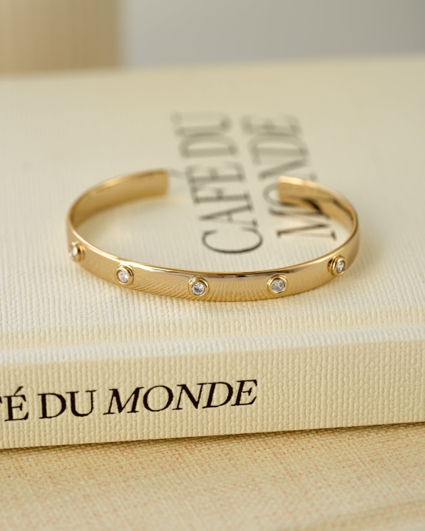 Vintage bracelet featuring a gold bangle on a decorative book
