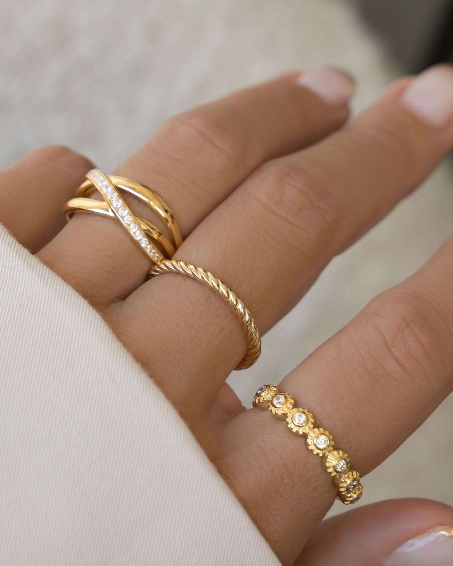 Model wearing three gold stackable rings