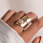model wearing gold summer jewelry featuring pearl statement ring