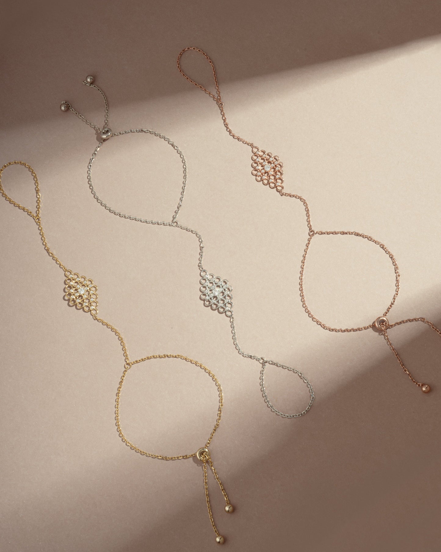 three adjustable hand chain bracelets, one gold hand chain, a rose gold ring bracelet, and a silver slave bracelet
