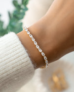 Gold dainty bracelet on model with oval cut stones