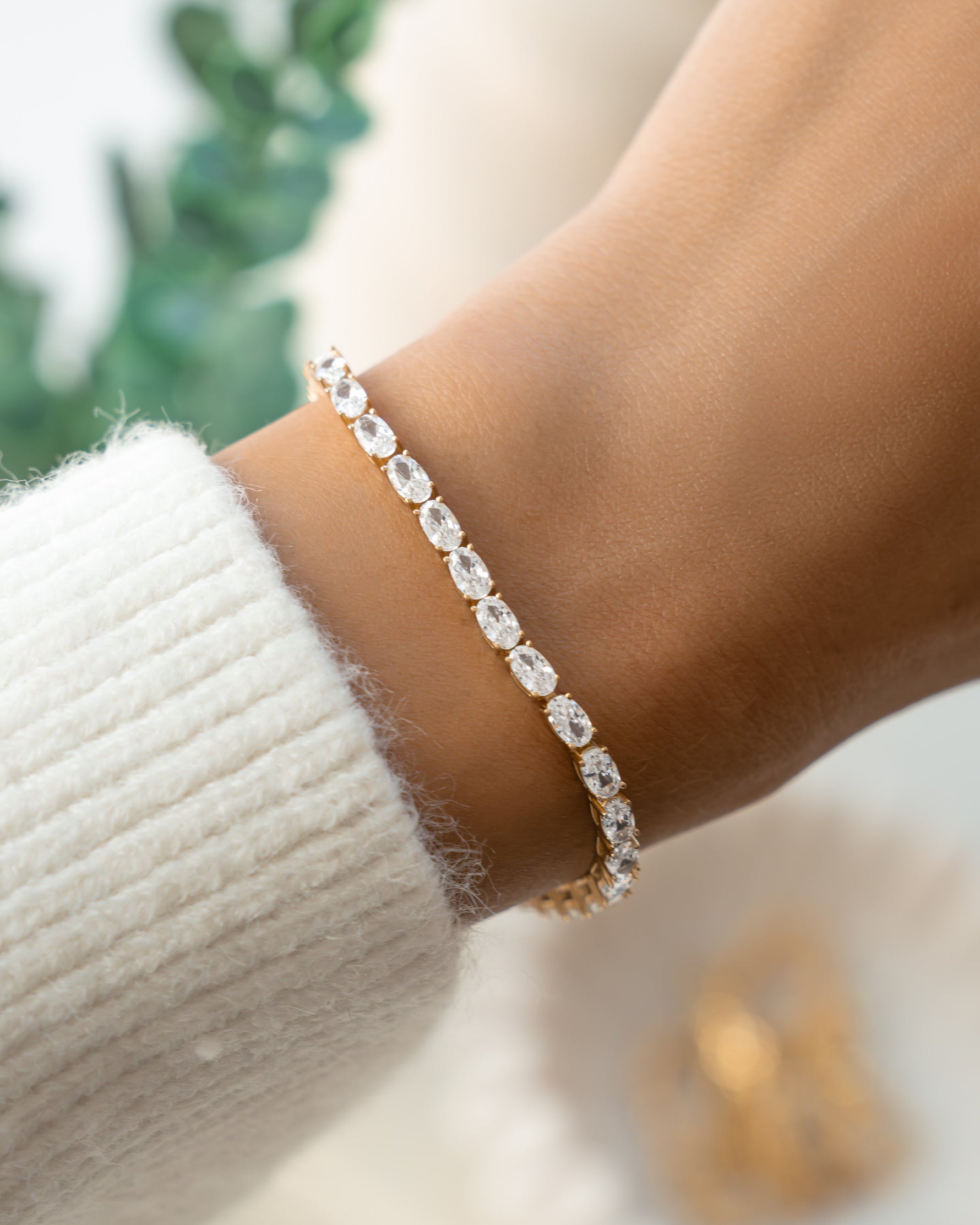 Gold dainty bracelet on model with oval cut stones