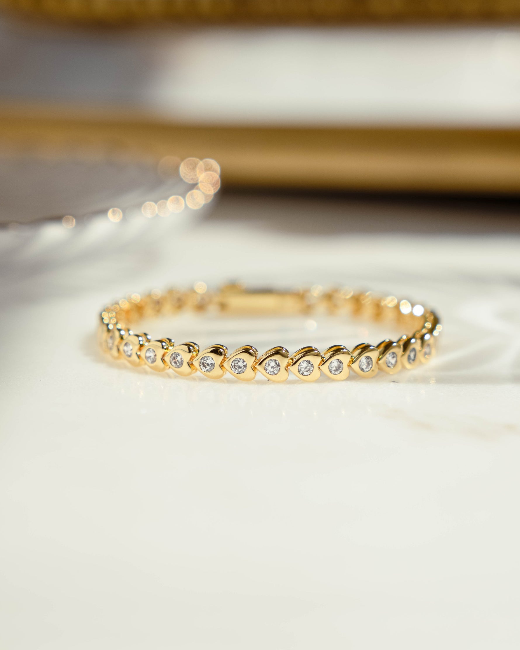 closeup image of gold heart shaped tennis bracelet