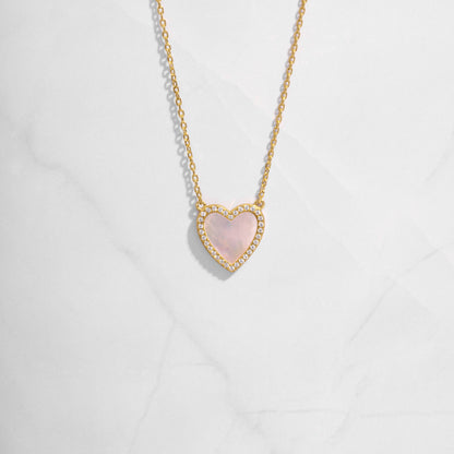 Close-up of a Mother of Pearl Heart Necklace with a smooth, luminous heart pendant on a delicate gold chain.