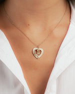 Gold heart necklace with rose pendant design on model