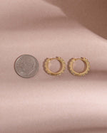 image comparing the size of our cubic zirconia studded hoops to a dime
